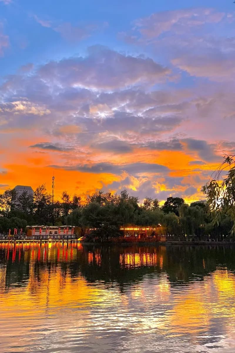 Green Lake at dusk with lanterns reflected in the water, Kunming