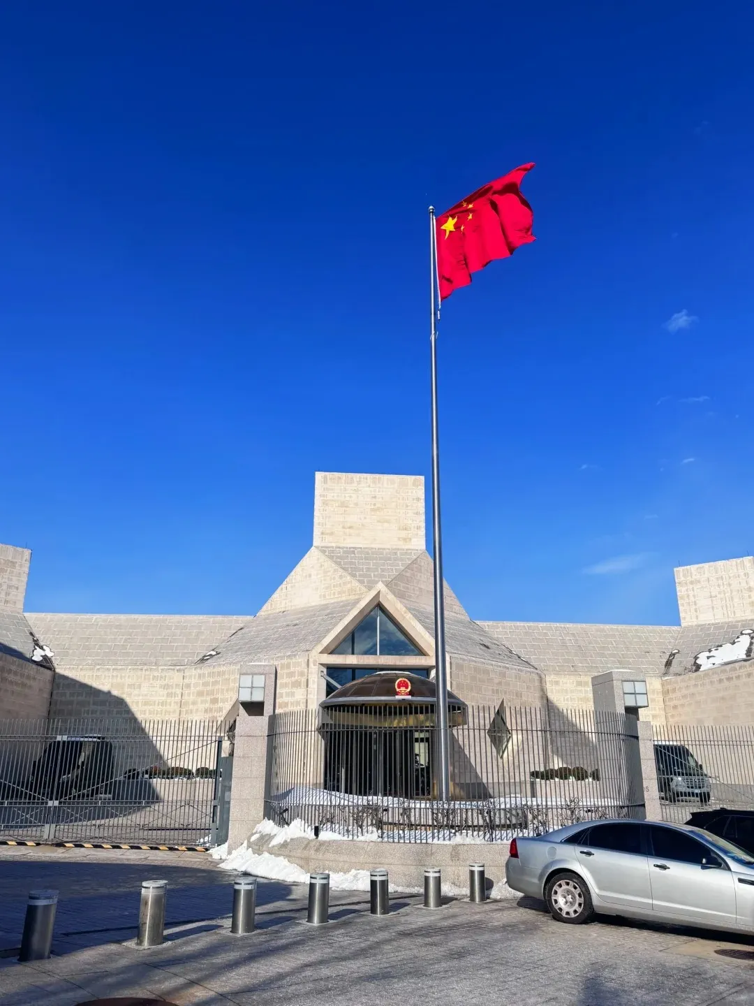 Chinese national flag flying outside a Chinese embassy building, representing China visa application requirements for foreign travelers