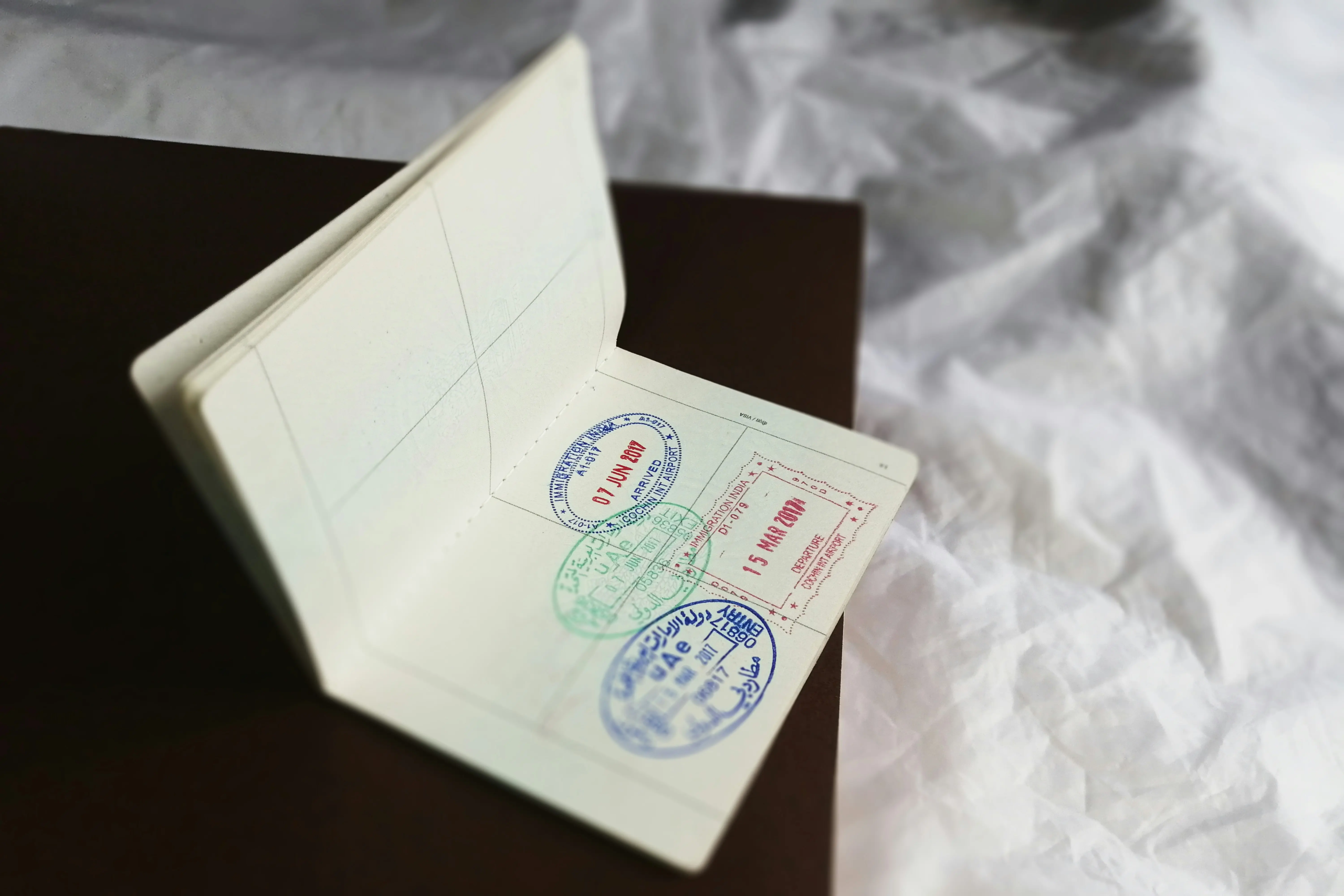 Open passport showing visa stamps from India and UAE, representing entry requirements for traveling to China