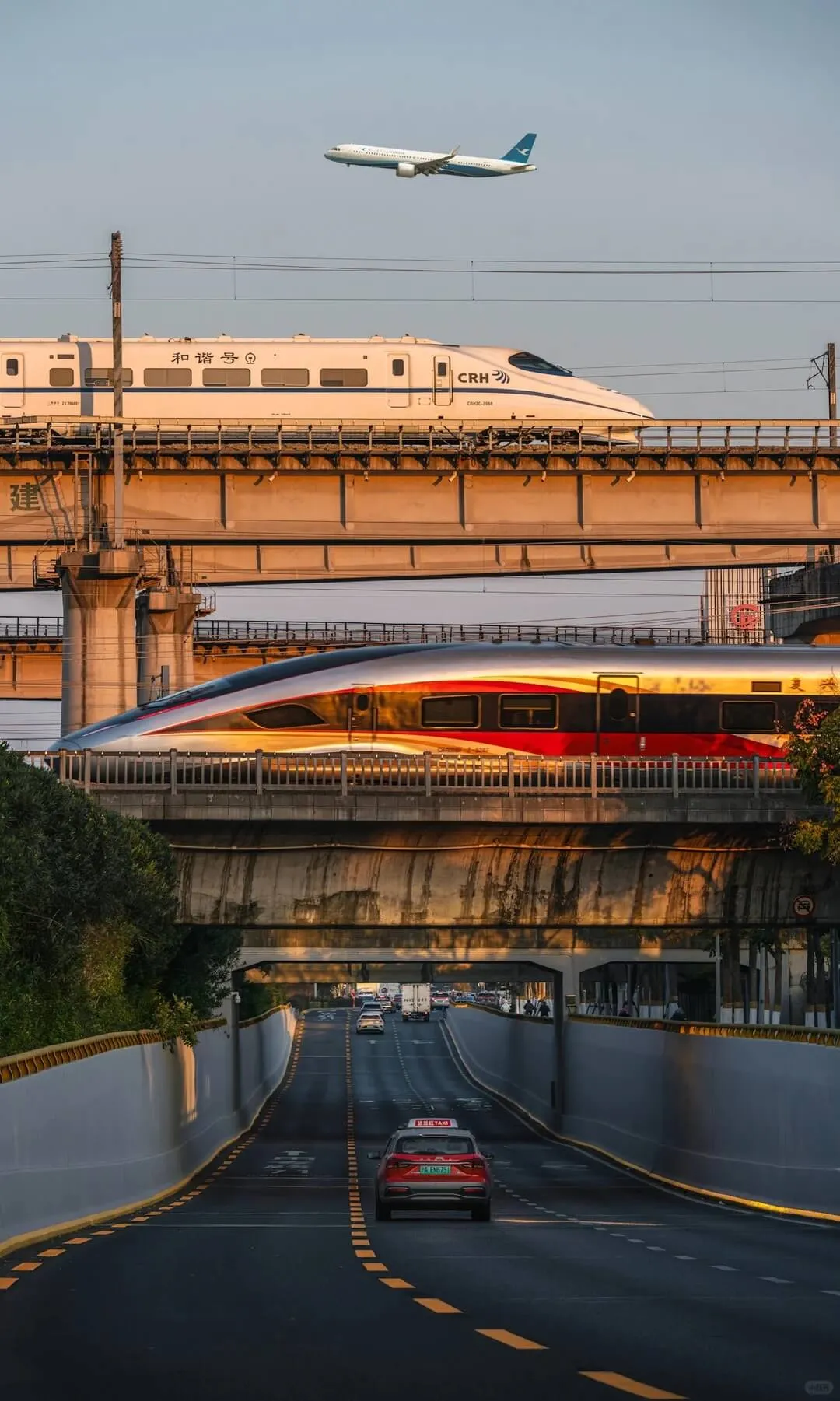 China high-speed rail CRH and Fuxing trains on elevated tracks at sunset, with a plane overhead — China transport for foreigners