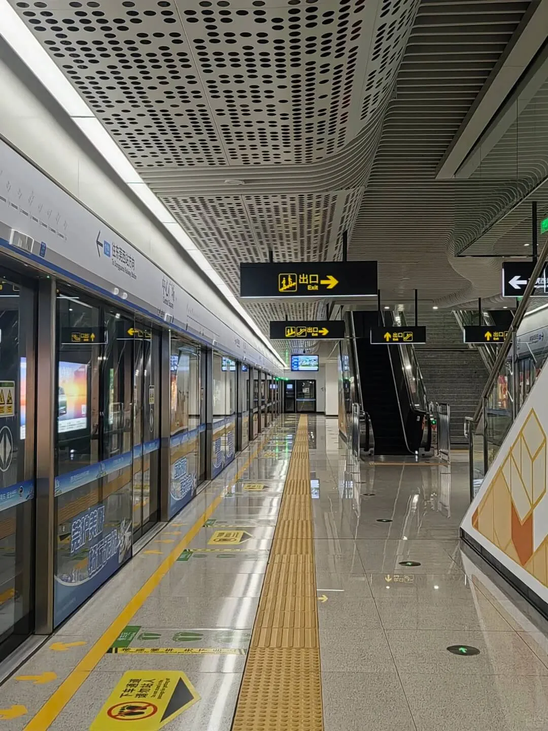 China metro station platform with train, yellow tactile strip, and bilingual exit signs — Dongguan Metro Line 1