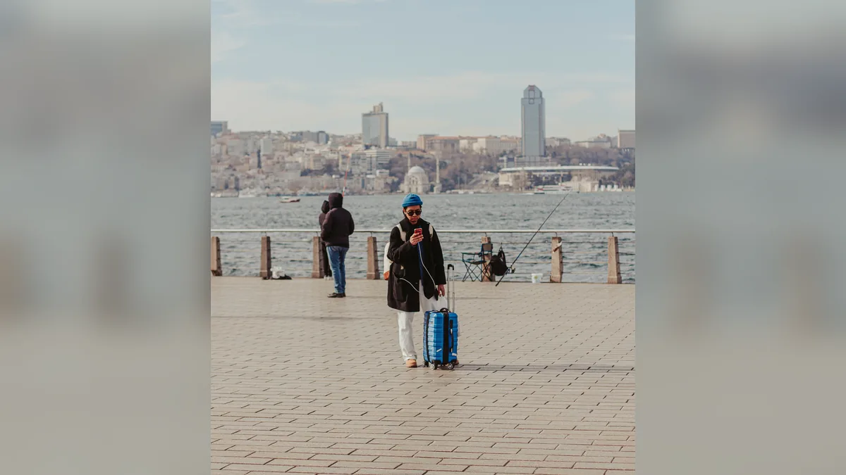 Traveler checking a phone beside luggage; illustrative stock photo, not the Yubeng field test