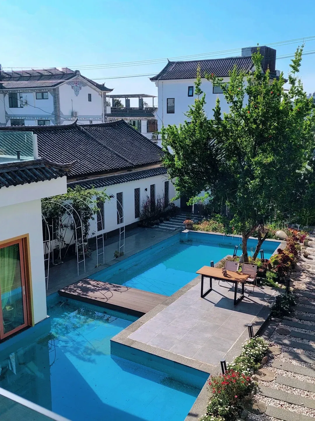 Courtyard pool at Dali Blue Habitat Inn, with Bai-style white walls and tiled roofs around a blue swimming pool