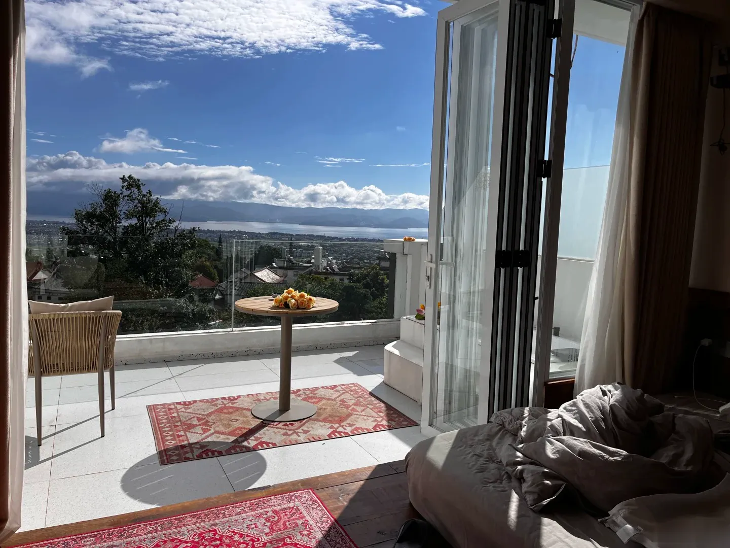 Room balcony at Dali Panshan Tinghai Homestay looking over rooftops toward Erhai Lake and the mountains